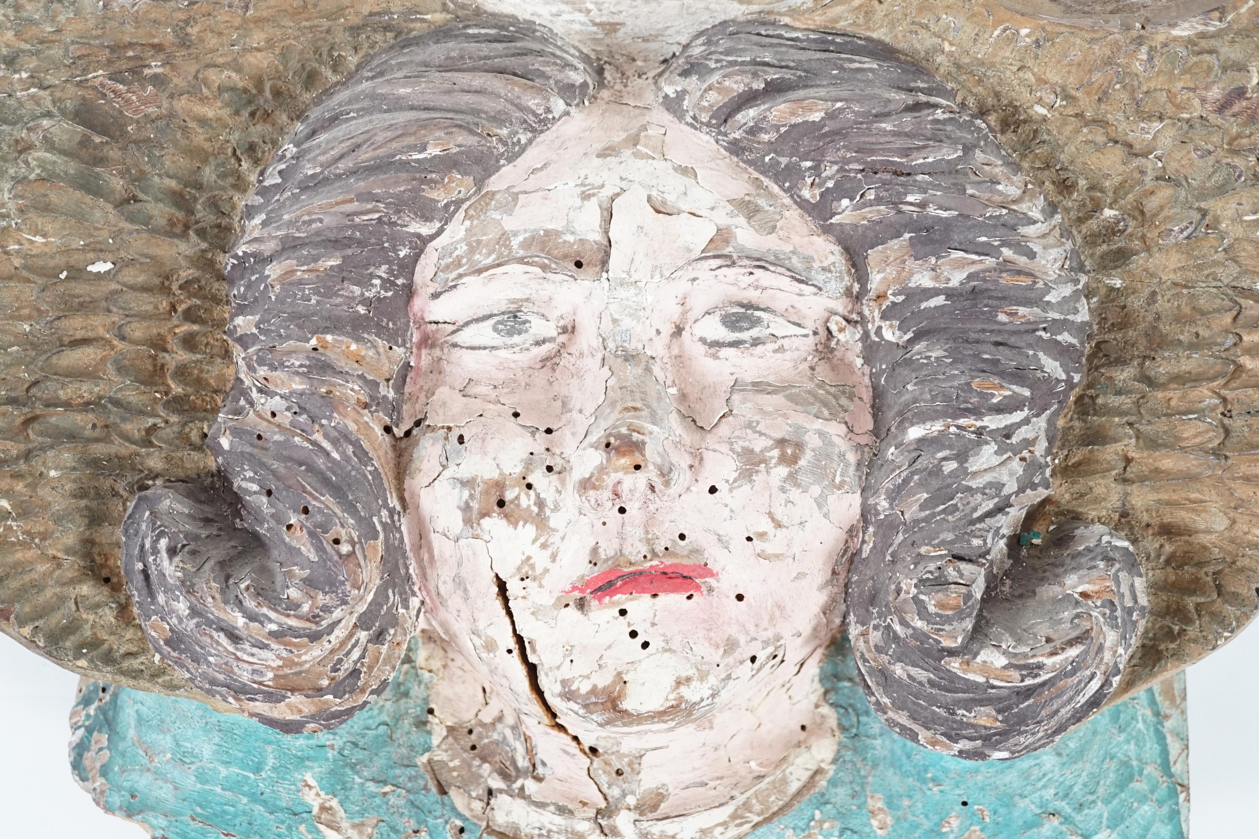 A 16th century French carved and painted wooden angel mask corbel